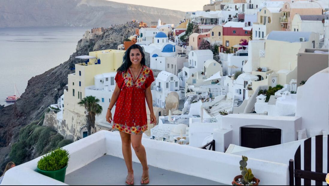 Woman in greece standing on cliff